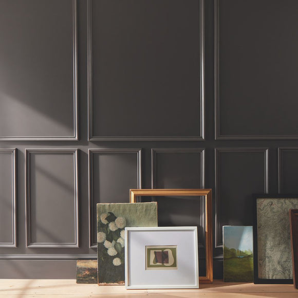 Framed artworks against a dark paneled wall. Benjamin Moore 2026 Color of the year Silhouette AF-655